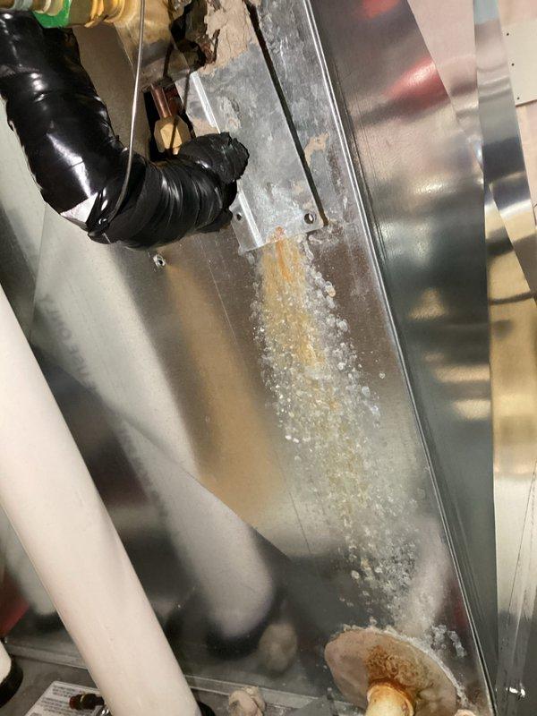 Responded to furnace condensate leak issue. Upon arrival, identified water leaking from condensate line due to missing seal around suction line penetration through cabinet. Sealed the opening around suction line to prevent further condensate leakage. System inspection revealed frost buildup on evaporator coil assembly and associated refrigerant lines, indicating proper cooling operation. Completed repairs and verified no additional leaks present.