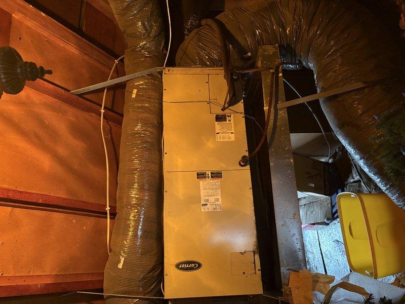 Responded to service call for attic-mounted Carrier air handler with compromised condensate drainage system. Upon inspection, discovered the secondary metal drain pan had rusted through with visible holes, and the primary drain hose was broken and non-functional. Removed the deteriorated metal drain pan and replaced it with a new plastic drain pan to prevent future corrosion issues and ensure proper condensate collection. Verified all drainage components were functioning correctly upon completion.