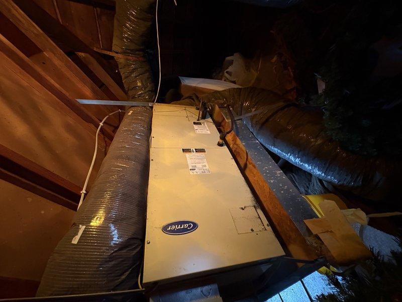 Responded to service call for attic-mounted Carrier air handler with compromised condensate drainage system. Upon inspection, discovered the secondary metal drain pan had rusted through with visible holes, and the primary drain hose was broken and non-functional. Removed the deteriorated metal drain pan and replaced it with a new plastic drain pan to prevent future corrosion issues and ensure proper condensate collection. Verified all drainage components were functioning correctly upon completion.