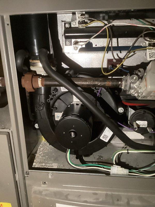 Responded to no heat call on residential furnace that had been inoperative for three weeks. Upon arrival, performed diagnostic assessment and identified failed inducer motor as root cause of heating system failure. Removed access panel to access internal components, disconnected electrical connections and pressure switch tubing from failed inducer assembly. Extracted defective inducer motor from furnace cabinet and installed new replacement inducer unit. Reconnected all electrical wiring, pressure switch hoses, and exhaust piping to new motor assembly. Tested system operation to verify proper inducer function, pressure switch activation, and ignition sequence. Confirmed furnace now heating properly and restored comfort to residence.