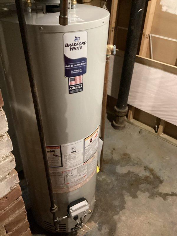 Responded to service call for leaking water heater in basement utility area. Drained and disconnected existing failed unit. Installed new Bradford White 40-gallon atmospheric vent water heater, model RG240T6N, with 40,000 BTU/hr natural gas input. Made all plumbing connections using existing copper supply lines and black gas piping. Connected natural draft venting system. Filled tank, purged air from lines, and lit pilot light. Tested gas valve operation and burner ignition. Verified proper venting and absence of leaks at all connections. Unit operating within manufacturer specifications upon completion.