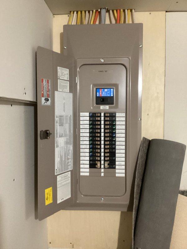 Completed comprehensive electrical inspection of residential property with focus on outlet concerns and overall system evaluation. Documented electrical panel with properly labeled circuit breakers and digital monitoring display, verified all connections secure with organized wiring entering through top conduit. Inspected auxiliary electrical installation including junction boxes, flexible metal conduit, and electronic control board housed in clear protective enclosure mounted on plywood backing. All components found to be properly installed and functioning within code specifications.