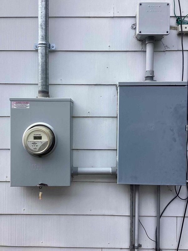 Responded to loss of power issue affecting garage door, hallway light, and multiple outlets that were tripping breaker. Upon investigation, diagnosed missing hot leg at electrical service entrance from meter. Coordinated with RPU to address utility-side power supply deficiency. Documented electrical meter and service panel configuration with photos showing exterior mounted components, conduit system, and service entrance equipment.