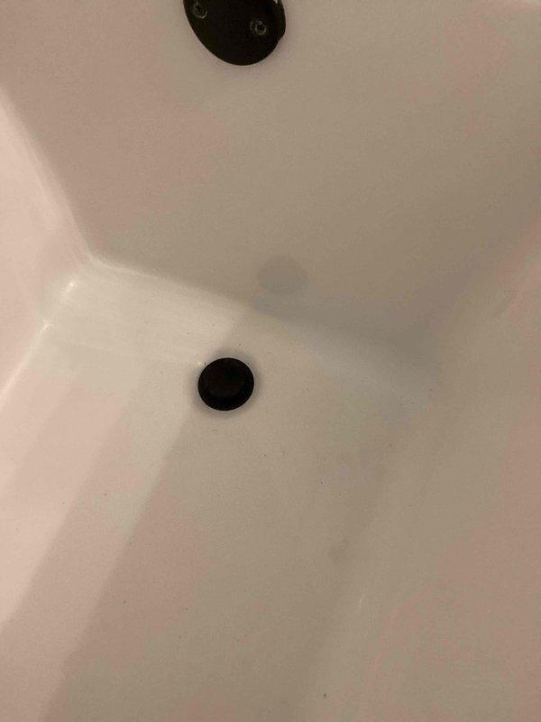 Responded to upstairs hallway bathroom tub drain leak caused by disassembled spring-loaded drain cover. Reinstalled drain assembly with new rubber gasket underneath and fresh bead of plumber's putty applied to backside of drain cover, securing it properly into the floor of the drain assembly. Performed leak test by filling tub completely and draining, confirming successful repair with no water leakage detected.