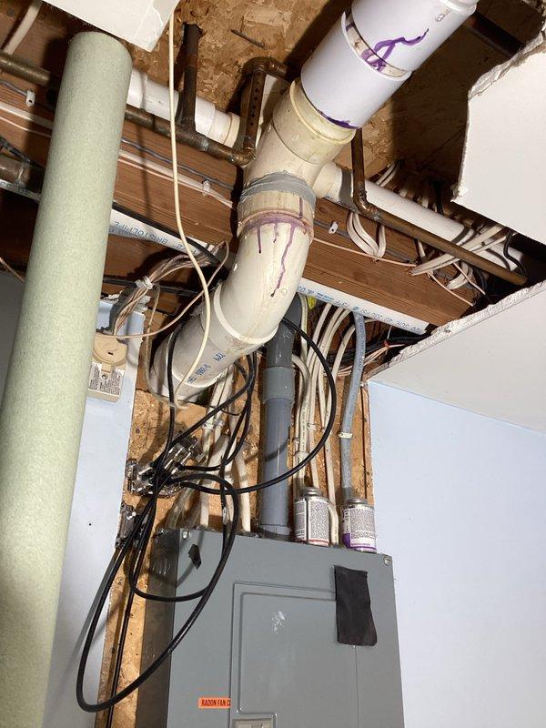 Inspection revealed a cracked 3-inch PVC drainage fitting near the hub connection in the shower/tub drainage system, causing an active leak in the crawl space area. Documented the damage with photographs showing the compromised P-trap assembly and surrounding plumbing infrastructure for insurance claim purposes, with repair scope requiring formal bid due to the extent of work needed.