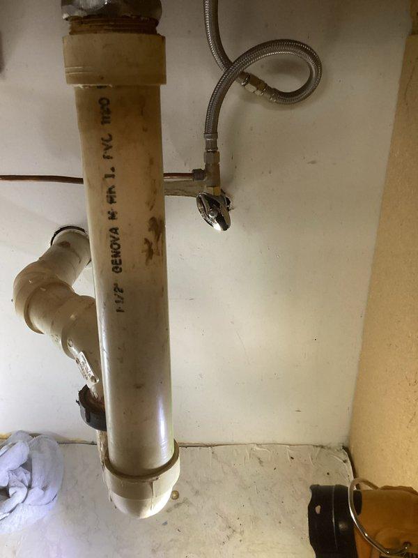 Responded to service call for leaking saddle valve on cold water supply line. Upon inspection, identified active leak at saddle valve connection point on vertical PVC cold water pipe. Removed defective saddle valve and replaced with new brass shut-off valve assembly featuring dual copper pipe connections and manual control handle. Tested installation for proper operation and verified no leaks present after replacement.