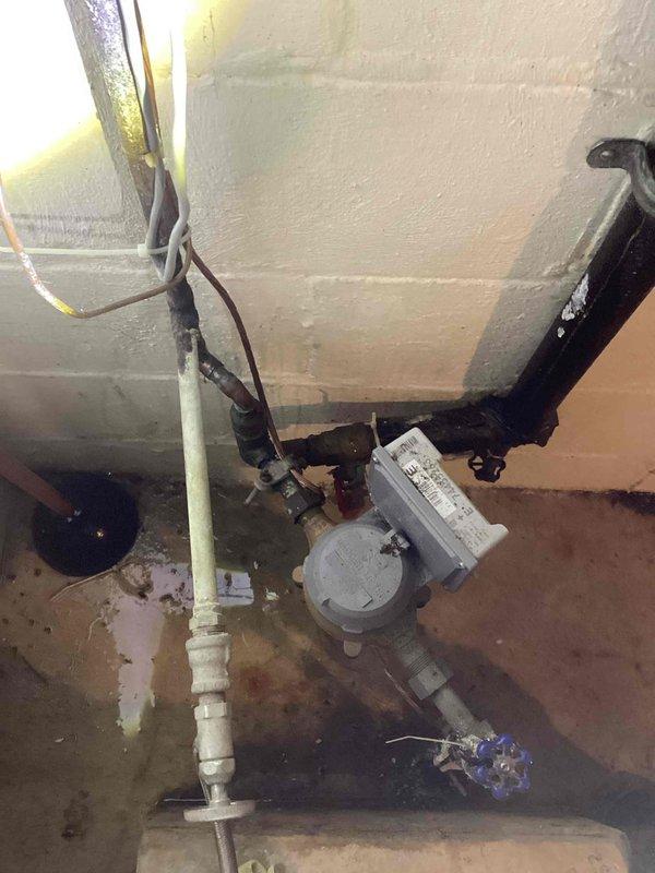 Responded to emergency call for burst pipe in basement. Upon arrival, located pinhole leak on 1/2" copper water main immediately after the meter. The leak was positioned near multiple existing fittings, requiring removal of compromised section. Cut out damaged copper pipe and old fittings, then installed new copper pipe with proper fittings to restore water main integrity. Tested system by restoring water service to the home and verified no additional leaks were present. All plumbing connections secured and water flow restored to normal operation.