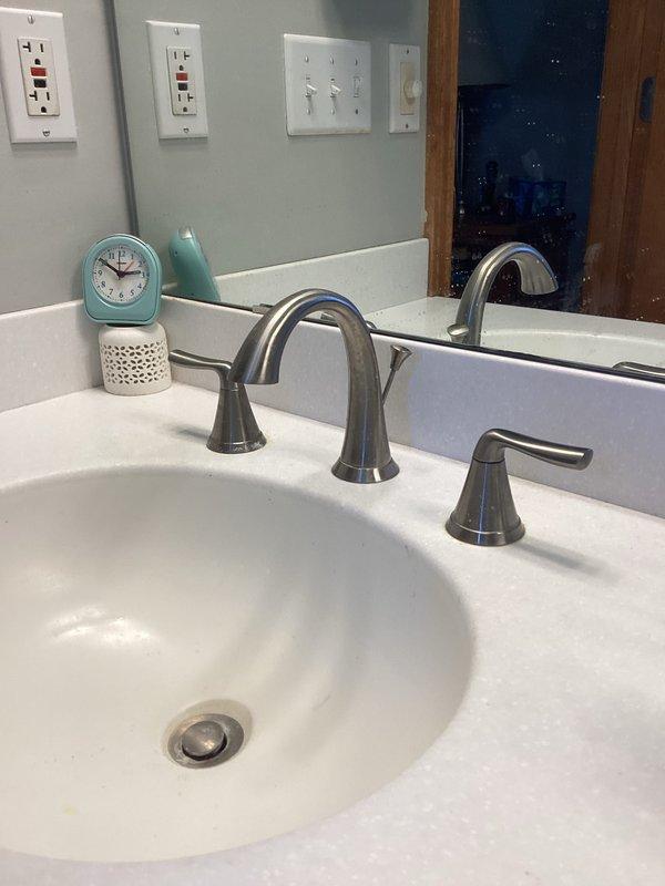 Removed two existing lavatory faucets in master bathroom and installed two new widespread faucets with brushed nickel finish. Disconnected water supply lines, removed old fixtures, and positioned new three-piece faucet assemblies with separate handles and center spouts on both vanity sinks. Made all necessary water supply connections, tested for leaks, restored water service, and verified proper operation of both installations.