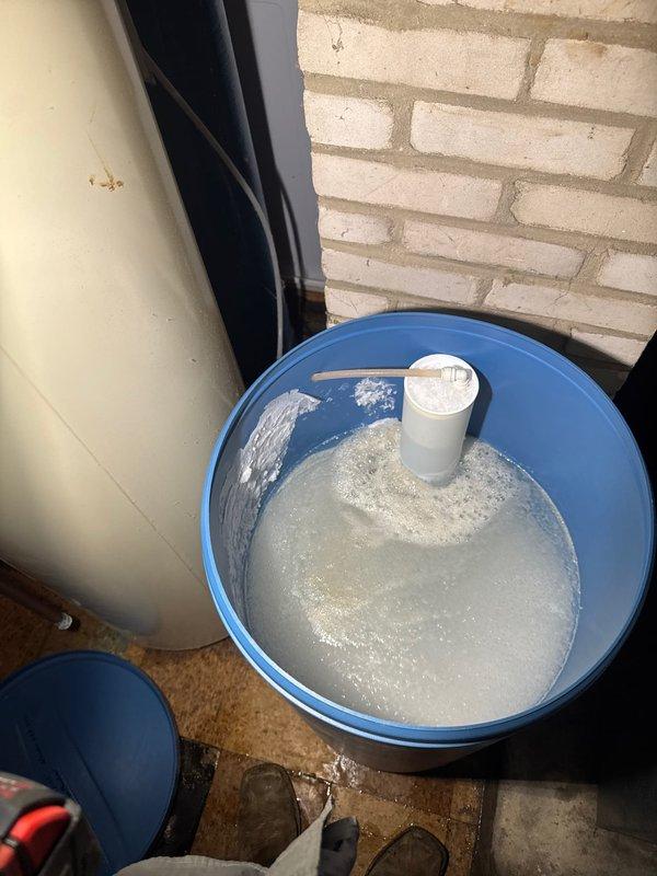 Responded to service call for water heater leak and water softener malfunction. Upon arrival, identified brine tank overflow condition on water softener system causing excess water discharge. Documented equipment setup including water heater, water softener with control head, and associated copper piping connections. Assessed brine tank failure requiring full replacement due to overflow malfunction. Collected diagnostic fee and captured photographic documentation of affected equipment and overflow condition for service records.