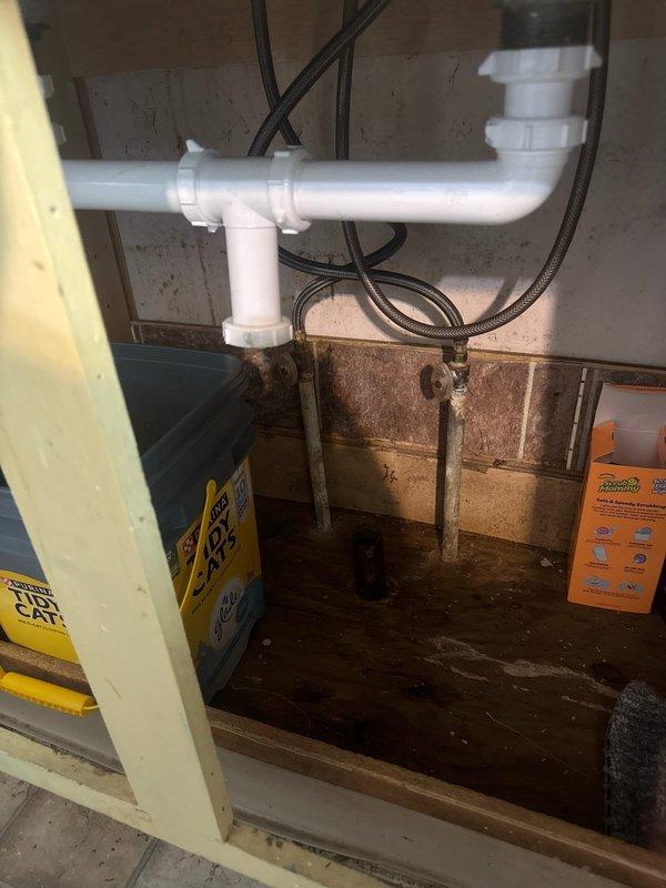 Responded to bathroom faucet issue and performed comprehensive plumbing assessment. Upon inspection, identified drainage system concerns in basement utility area with standing water present beneath floor joists, indicating potential moisture management issues affecting overall plumbing system. Documented existing PVC drainage configuration and copper supply lines for service records and provided estimates for necessary repairs.