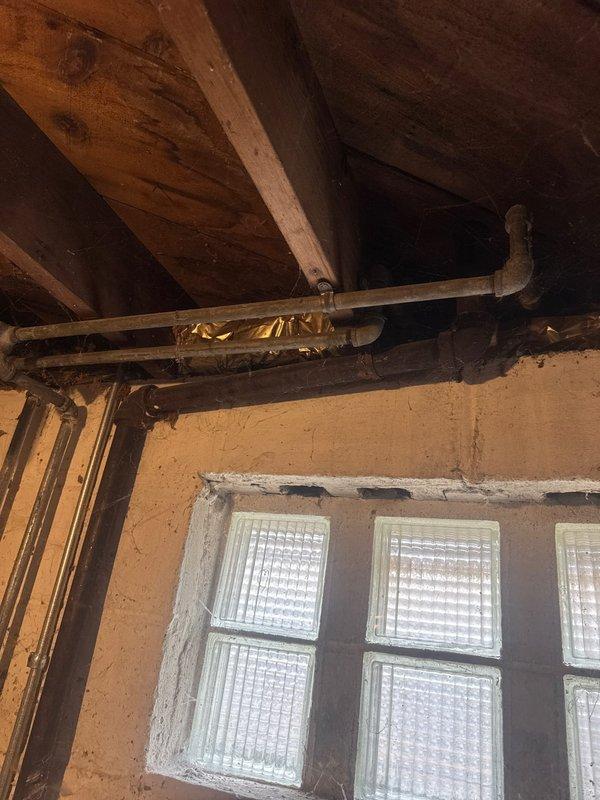 Responded to bathroom faucet issue and performed comprehensive plumbing assessment. Upon inspection, identified drainage system concerns in basement utility area with standing water present beneath floor joists, indicating potential moisture management issues affecting overall plumbing system. Documented existing PVC drainage configuration and copper supply lines for service records and provided estimates for necessary repairs.