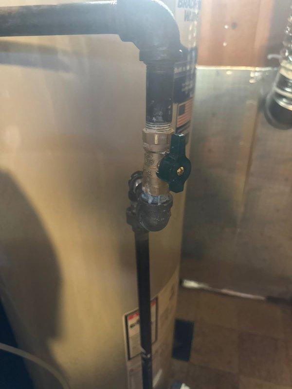 Responded to service call for leaking water softener system. Upon arrival, assessed the utility room and confirmed active leak from the water softener unit. Replaced the failed water softener with new unit, installing beige cylindrical softener tank with black base and white digital control valve system. Installed new Bradford White tanked water heater to replace existing unit. Connected expansion tank to water heater using proper valve assembly with manual shutoff capability. Completed all copper and galvanized pipe connections between water softener, control unit, and water heater with appropriate shut-off valves and fittings throughout the system. Verified all plumbing connections for proper operation and tested system to ensure no leaks present. Left installation clean and fully operational with all equipment functioning as designed.