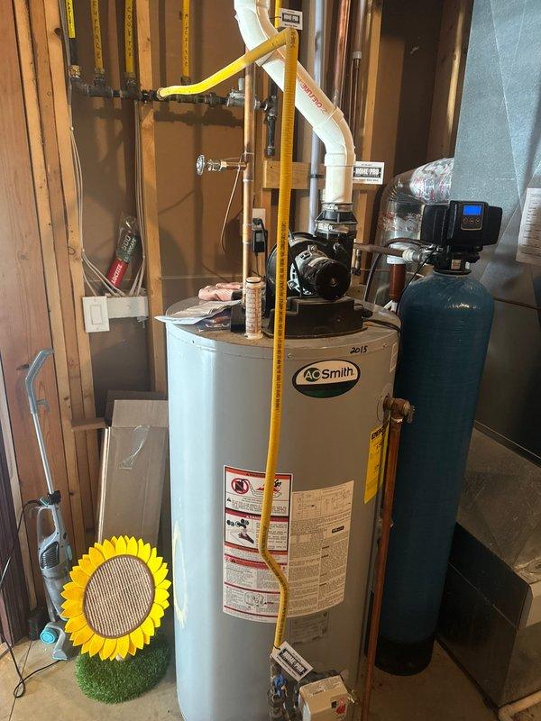 Responded to service call for leaking water heater in residential basement utility area. Upon arrival, confirmed active leak from A.O. Smith tanked water heater requiring full unit replacement. Removed failed water heater and installed new A.O. Smith residential tanked water heater unit. Connected water supply lines, installed proper venting system using PVC piping with appropriate fittings and couplings, and ensured all connections were secure and code-compliant. Verified proper integration with existing water treatment system including blue filtration tank. Tested new water heater for proper operation, confirmed no leaks at all connection points, and ensured safe venting through ceiling infrastructure. Unit operational and performing as specified upon completion.