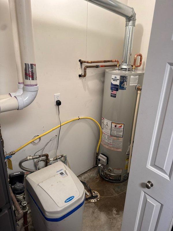 Responded to service call for leaking water heater in residential utility closet. Upon arrival, confirmed existing water heater had developed active leak requiring immediate replacement. Removed and disposed of failed unit. Installed new 40-gallon Bradford White residential water heater per estimate specifications. Connected hot and cold water supply lines using copper piping with brass fittings and heat trap assembly. Attached galvanized metal vent pipe for proper exhaust ventilation. Connected yellow flexible gas line to unit and verified all gas connections for safety and code compliance. Installed temperature and pressure relief valve with PVC discharge pipe. Tested all connections for leaks, verified proper gas flow, and confirmed unit ignition and operation. System is fully functional with no leaks detected.