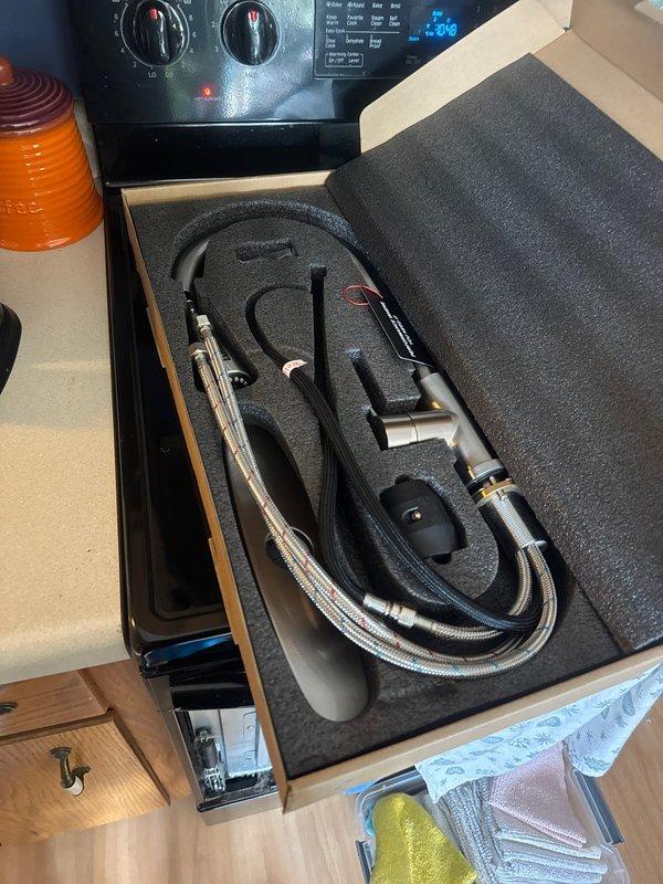 Responded to service call for malfunctioning kitchen faucet. Upon arrival, assessed the existing black single-handle faucet on double-basin stainless steel sink and determined replacement was necessary. Installed new faucet assembly and added stop valves to provide proper water shut-off capability for future maintenance. Tested installation to ensure proper operation and verified no leaks at connections.