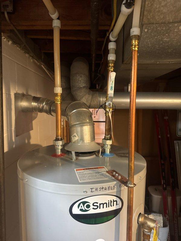 Responded to service call for non-operational gas water heater. Upon arrival, diagnosed gas valve failure indicated by error code on A.O. Smith tanked water heater unit. Determined gas valve was defective and beyond repair. Proceeded with complete water heater replacement due to component failure. Removed existing failed unit and installed new A.O. Smith residential gas water heater in basement utility area. Connected all necessary copper water supply lines with proper brass fittings, installed expansion tank, and established appropriate hot and cold water connections with shut-off valves. Verified all plumbing connections for proper seal and tested gas line connections for safety. Commissioned new unit, confirmed proper ignition sequence, and validated water heating functionality. System restored to full operational status.