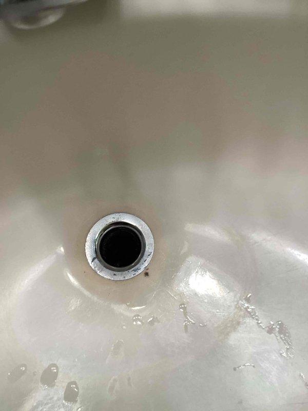 Responded to a clogged master bathroom lavatory drain caused by a spring-loaded pop-up assembly component that had become dislodged and fallen into the drain line. Disassembled the drain trap and tailpiece to access and remove the obstructing piece, cleared the blockage, and reassembled the drain system to restore proper drainage function.