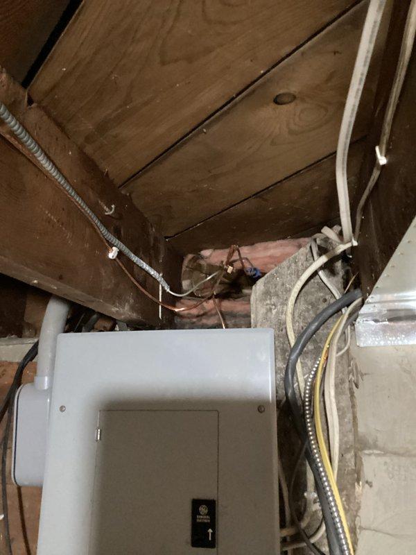 Completed CSST bonding installation in accordance with safety codes. Located yellow flexible corrugated stainless steel tubing (CSST) gas line connected to water heater system in basement utility area. Installed proper electrical bonding jumper from CSST gas piping system to electrical grounding system at main panel to protect against lightning strikes and electrical faults. Verified all connections were secure and met code requirements for gas line bonding.