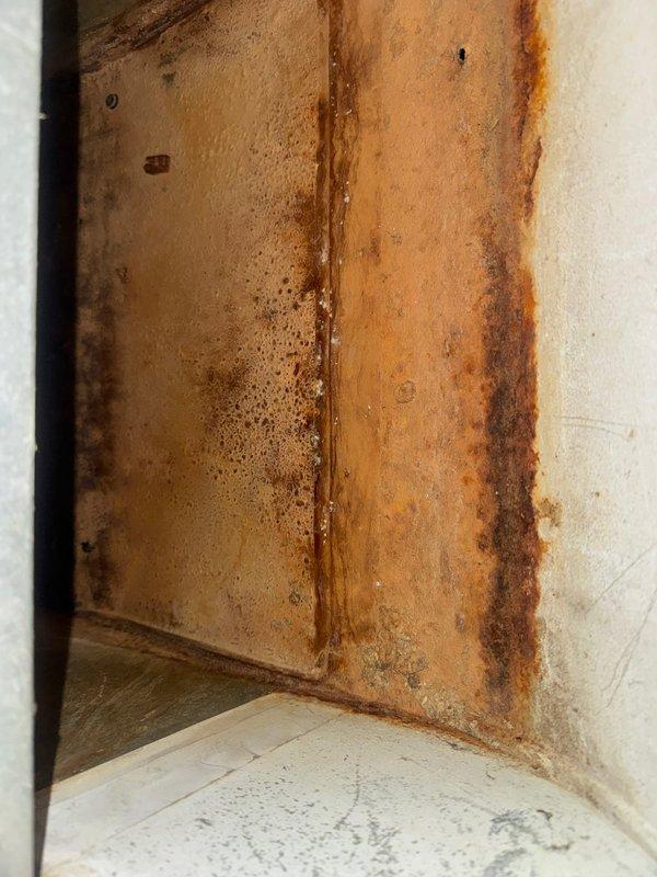 Responded to service call for geothermal system emitting odor during operation. Upon inspection, identified source as 30-year-old fan coil unit with severely deteriorated electrical wiring showing burn marks and exposed conductors, along with heavily corroded drain pan causing water leakage into return air plenum. Due to safety hazards and extent of deterioration, de-energized fan coil unit at breaker and documented conditions with photographs. Coordinated with project management team to schedule equipment replacement estimate.