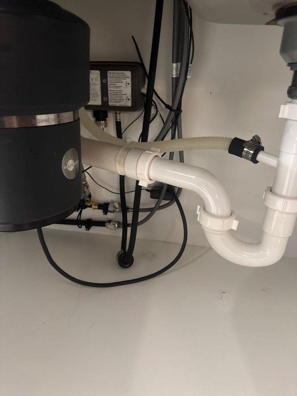 Completed installation of customer-supplied brushed stainless steel kitchen faucet with pull-down sprayer head on double-basin undermount sink. Verified proper water supply connections, tested faucet operation and spray function, and confirmed no leaks in the system.