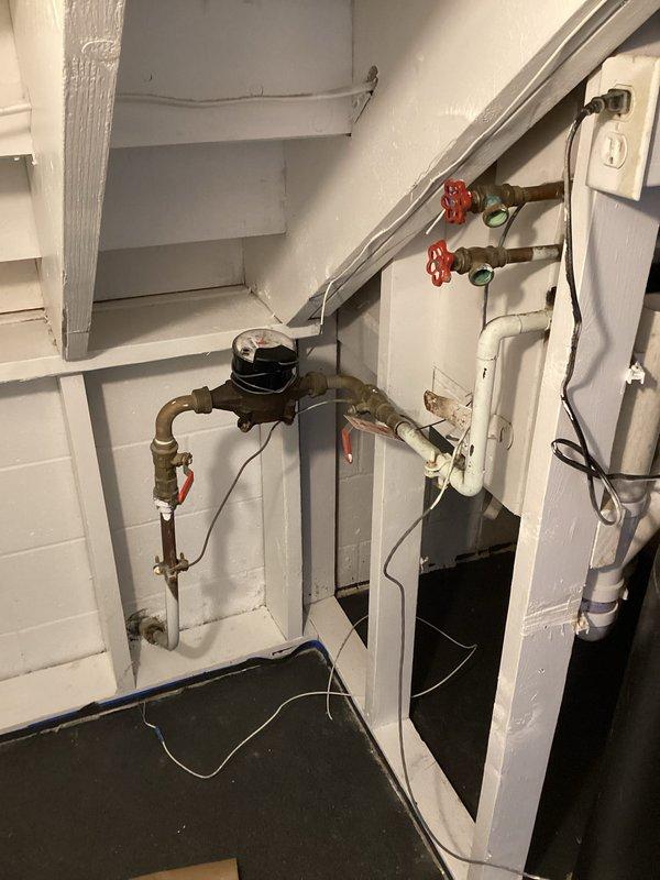 Completed installation of customer-supplied water treatment system including sediment filter and water softener unit in basement utility area. Connected black cylindrical water softener tank with digital control head to existing copper plumbing infrastructure using appropriate fittings and shut-off valves. Integrated sediment pre-filter into water supply line upstream of softener to protect system components and extend equipment lifespan. All connections properly secured and tested for leaks, with system positioned adjacent to existing water heater for optimal space utilization and plumbing efficiency.