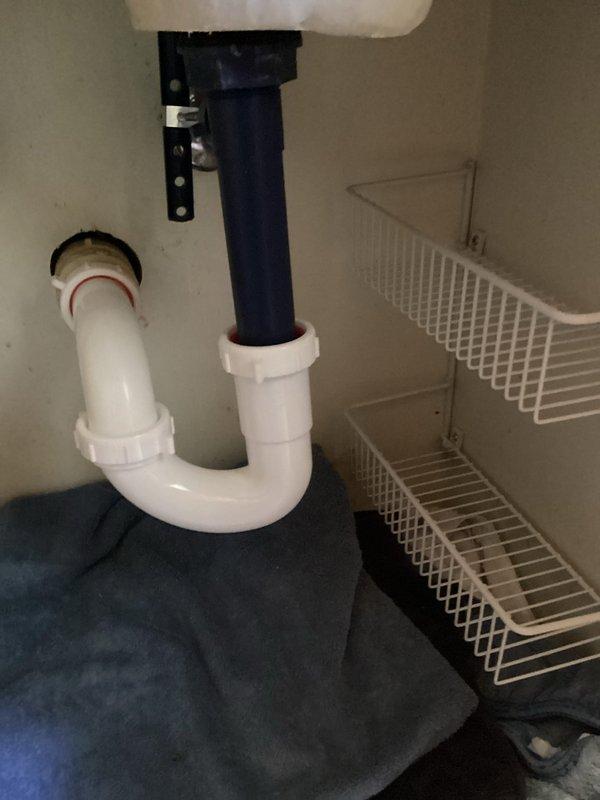 Responded to a water leak at a main floor hallway bathroom lavatory sink. Upon inspection, discovered the pop-up drain assembly and P-trap were deteriorated, cracked, and actively leaking beneath the vanity. Removed the failed pop-up assembly and P-trap drain components. Installed new pop-up drain assembly and P-trap, ensuring proper threaded connections and secure fittings. Tested the system by running the faucet to verify complete water flow and confirmed all connections were leak-free with no drainage issues.