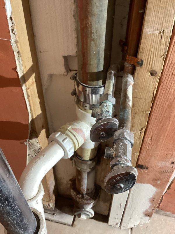 Responded to service call for bar sink removal and plumbing disconnection. Upon arrival, cut and removed existing drain line and water supply lines serving the old bar sink. Disconnected and removed P-trap drain assembly from the drainage system. Cut and properly capped both 1/2" hot and cold water supply lines to eliminate the bar sink connection points. Secured loose PVC piping and water connections in the wall cavity to prevent future interference. Restored water service to the home and performed system check to verify all connections were watertight and functioning properly with no leaks detected.