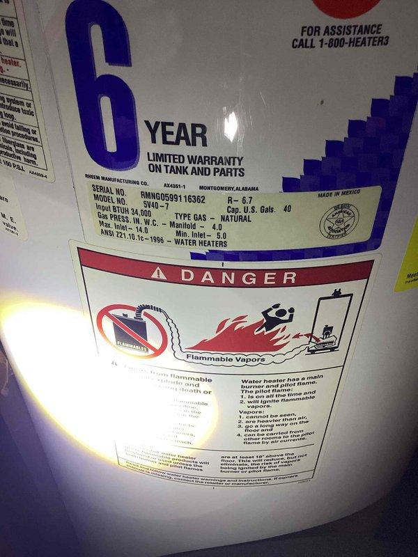 Responded to service call for gas water heater leaking at base. Upon arrival, inspected 40-gallon natural gas atmospheric vent water heater (Rheem model RHNNG59916362) and identified active water leak. Traced leak source to internal tank failure rather than supply line connections. Confirmed water was leaking directly through the tank body, indicating irreparable structural compromise of the pressure vessel. Documented unit specifications including 6-year limited warranty coverage on tank and parts, serial number SN40-7, and ANSI Z21.10.1c-1996 certification. Photographed manufacturer labels, warranty information, and safety warnings for service records. Advised that internal tank leaks cannot be repaired and unit requires complete replacement. Recommended installation of new 40-gallon natural gas atmospheric vent water heater to restore hot water service.