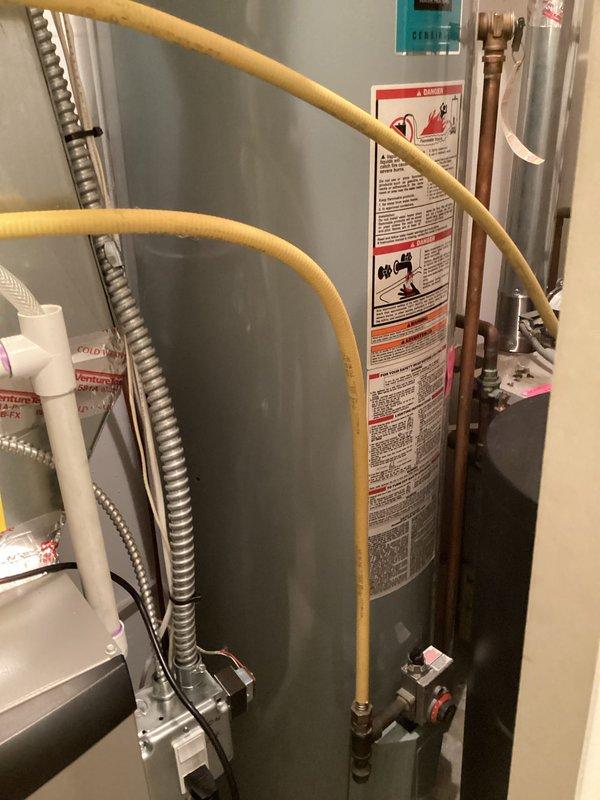 Technician arrived during scheduled window to assess existing 50-gallon atmospheric water heater for replacement. Conducted thorough inspection of current installation located in utility closet adjacent to Lennox furnace system. Evaluated existing plumbing configuration including copper supply lines, gas connections with flexible yellow gas line, and venting arrangement with existing PVC and metallic vent piping. Customer expressed interest in upgrading to a higher recovery, more efficient water heater model to improve hot water availability. Documented current installation with photographs showing equipment placement, gas valve connections, supply line routing, and available clearances in confined utility space. Assessed compatibility requirements for upgraded unit including gas line capacity, venting modifications, electrical connections if applicable, and spatial constraints within existing mechanical room. Prepared detailed estimate for replacement with higher-efficiency water heat