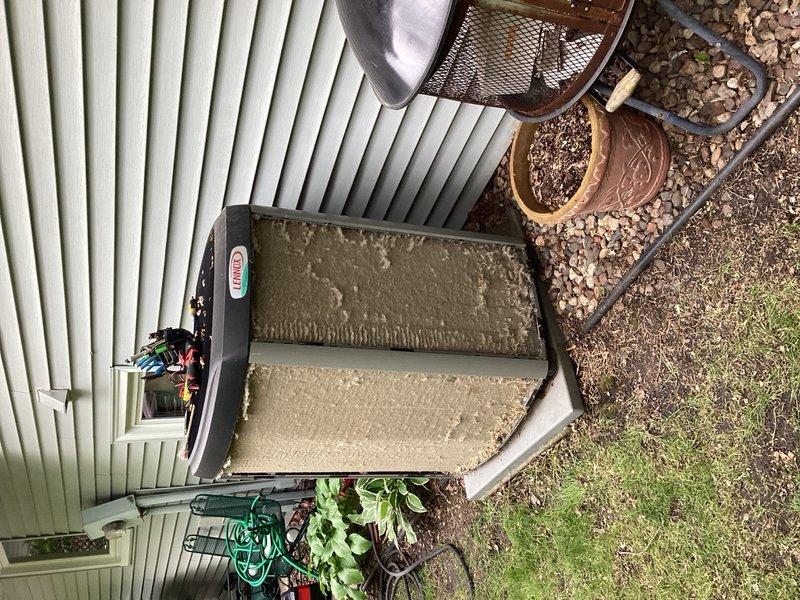 Responded to no cooling call with error message displayed at thermostat. Upon arrival, found outdoor condensing unit extremely dirty with heavy accumulation of debris, moss, and organic growth on exterior surfaces. Diagnostic testing revealed outdoor capacitor reading below manufacturer specifications. Performed complete system maintenance including coil cleaning and replaced failed capacitor. System restored to proper cooling operation and tested for normal performance.