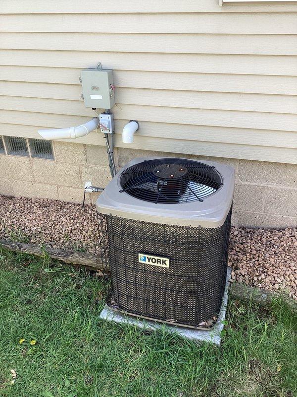 Responded to no cooling complaint on York air conditioning system. Upon arrival, found extensive frost buildup on refrigerant lines in basement area, indicating system malfunction. Performed diagnostic evaluation and identified active refrigerant leak in the system. Due to the age of the unit and the extent of repairs required, recommended complete system replacement as the most cost-effective solution. Documented conditions with photographs showing frosted suction line and outdoor condensing unit.