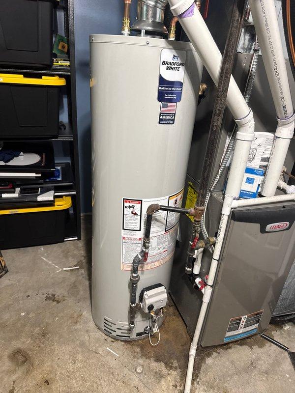 Responded to service call for non-functional and leaking water heater. Removed failed unit and installed new 40-gallon natural gas Bradford White water heater. Connected all water supply lines, gas piping, and venting system to manufacturer specifications. Verified proper operation, checked for leaks, and ensured all safety controls functioning correctly.