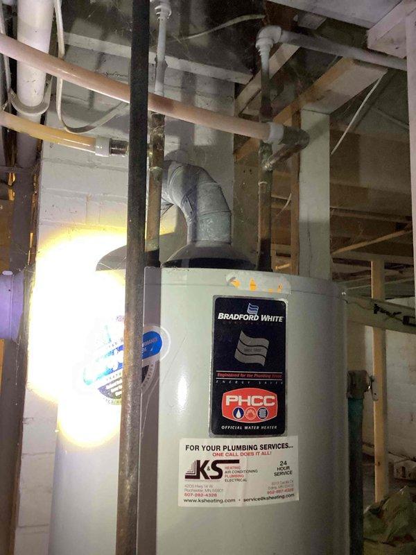 Responded to service call for Bradford White 40-gallon natural gas water heater that would not stay lit. Upon inspection, found burner assembly heavily corroded and contaminated with debris. Removed and thoroughly cleaned burner assembly, then installed new thermocouple. Reassembled unit and attempted to relight pilot, but flame extinguished immediately upon releasing igniter button, indicating failure beyond thermocouple replacement. Due to extent of corrosion and component failure, provided estimate for complete water heater replacement.