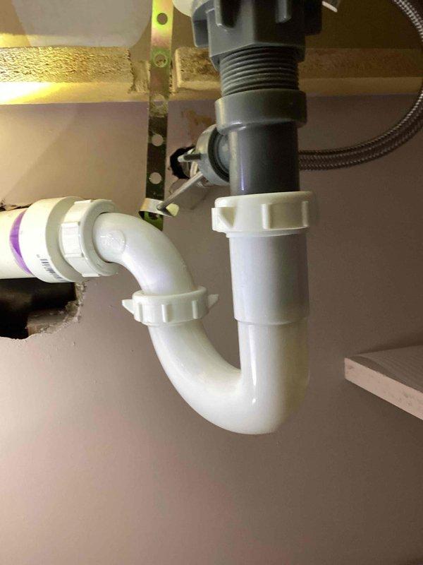 Responded to call regarding leak under sink in basement bathroom. Upon arrival, inspected the lavatory faucet supply lines and identified a loose compression nut on the cold side angle stop valve. Tightened the compression nut to proper specification and tested the system by running water through the fixture. Verified repair was successful with no further leakage detected. Photos documented the completed work.