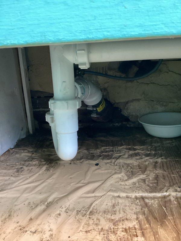 Responded to emergency call for burst pipe causing water intrusion from upper apartment unit into basement area below. Upon inspection, identified kitchen sink drain line leaking at cast iron connection point beneath sink. Attempted initial repair at P-trap and drain connection using standard methods, but leak persisted due to compromised connection integrity. Determined that repair access point needed to be established further downstream along drain line to achieve secure, watertight connection. Due to time constraints and scope of work required, job was rescheduled to allow for proper access and complete repair of drain system.