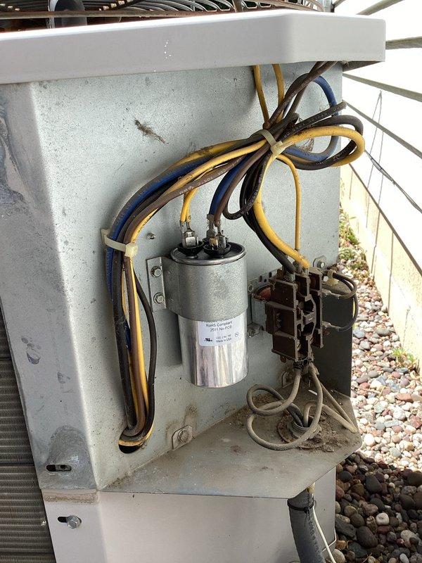 Responded to no cooling call on 30-year-old residential air conditioning system. Diagnosed failed dual run capacitor preventing compressor and condenser fan operation. Removed defective capacitor from electrical compartment and installed replacement capacitor with proper microfarad rating, restoring system to normal cooling operation.