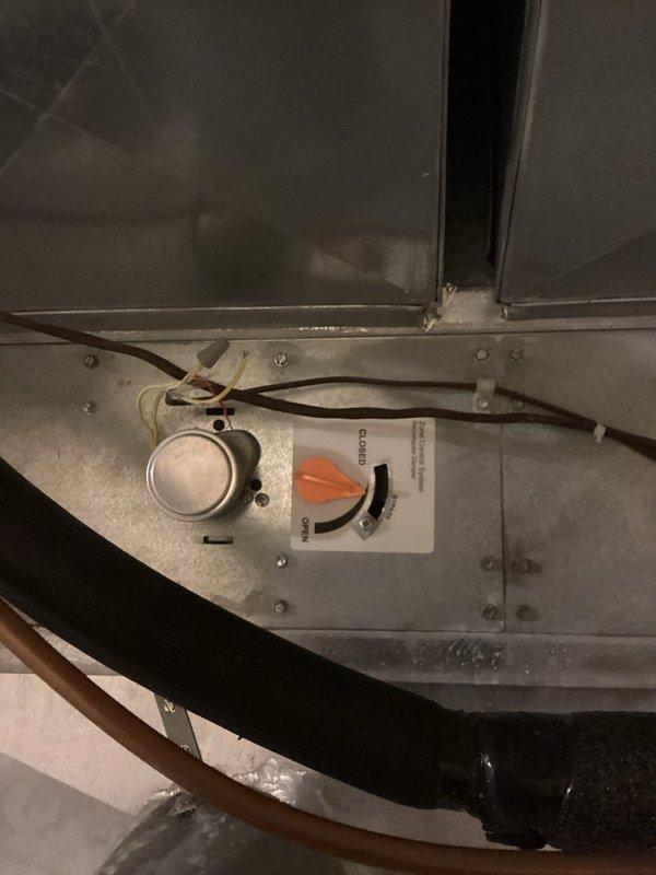 # HVAC Service Report - No Cool Condition Resolved

Responded to a no cooling complaint affecting the upstairs zone of the residence. Upon arrival, conducted a systematic evaluation of the HVAC system to identify the root cause of inadequate air distribution. 

Inspection revealed the basement zone damper was mechanically stuck in the open position, preventing proper airflow to the upstairs living areas. The damper actuator showed signs of age-related wear and had failed to modulate between open and closed positions as designed. This malfunction caused excessive airflow to redirect to the basement zone while starving the upper level of conditioned air.

Removed the defective damper assembly and installed a replacement motorized damper with new control interface. Verified proper operation of the damper actuator through multiple open/close cycles. Confirmed the control lever moved freely through its full range of motion and responded correctly to system calls. Tested both zones for adequ
