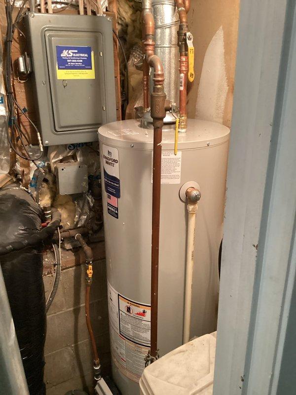 Completed full replacement of 40-gallon natural gas water heater in basement utility area. Removed existing unit and installed new white residential water heater with proper copper piping connections, brass fittings, and valves. Ensured all plumbing connections were secure and compliant with code requirements, including proper venting and gas line connections. Homeowner was not present during service; accessed property as arranged and coordinated completion confirmation upon finishing the installation.