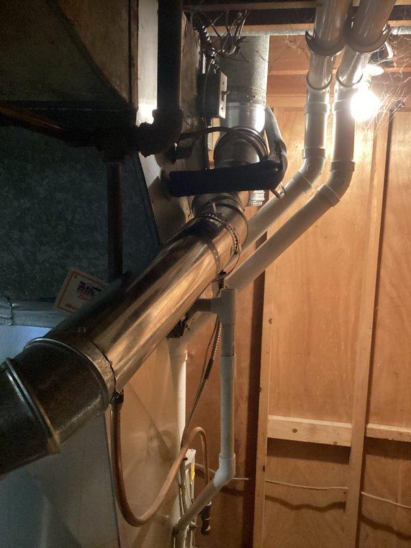 Completed installation of 40-gallon tanked water heater in basement utility area. Unit was positioned and secured with all necessary plumbing connections, including copper supply lines, pressure relief valve with discharge piping, and proper venting through existing ductwork. Installation included expansion tank mounted to cold water supply line and all code-compliant safety components.