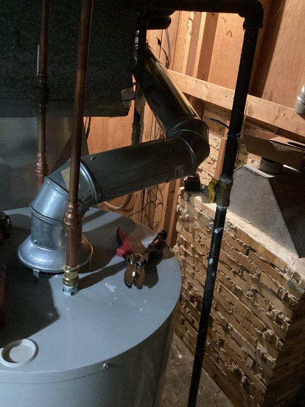 Completed installation of 40-gallon tanked water heater in basement utility area. Unit was positioned and secured with all necessary plumbing connections, including copper supply lines, pressure relief valve with discharge piping, and proper venting through existing ductwork. Installation included expansion tank mounted to cold water supply line and all code-compliant safety components.