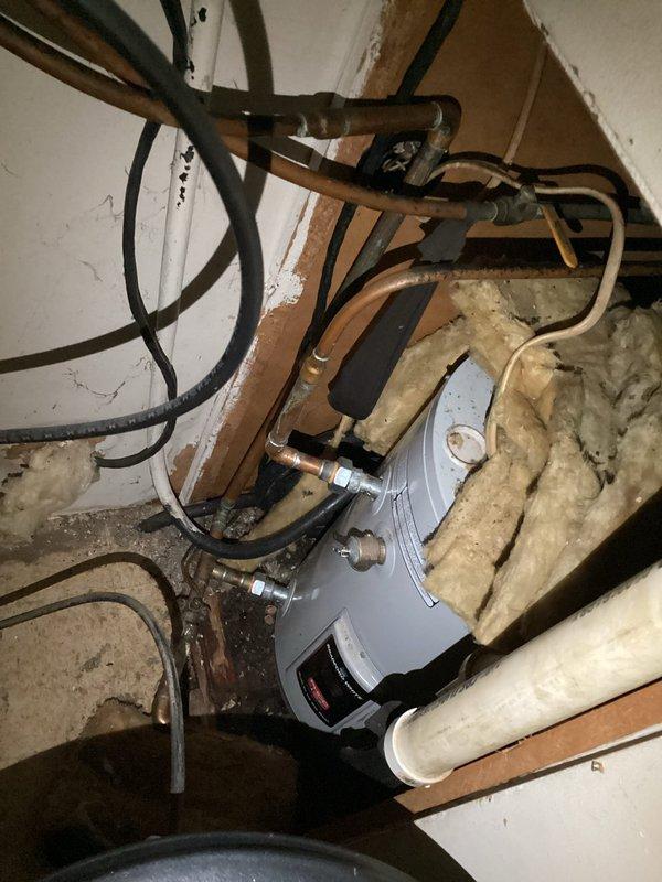 Responded to emergency call for active water leak at mobile home. Upon arrival, found electric water heater with continuous leak causing water accumulation on floor. Customer had already shut off water supply valve, but leak persisted until proper isolation valve was closed. Assessed water heater condition in confined crawl space area with limited access. Unit showed signs of failure requiring full replacement. Shut off power at electrical breaker panel and completed water supply isolation. Removed failed electric water heater unit from mechanical space. Installed replacement electric water heater with new connections to existing electrical service and plumbing lines. Verified all connections for proper seal and tested system operation. Restored power and water supply, confirmed no leaks present, and ensured proper hot water delivery throughout residence.