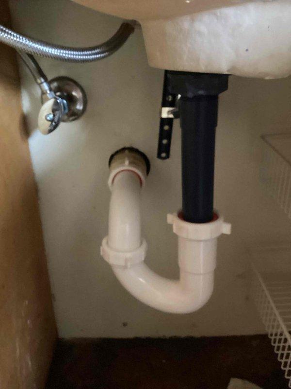 Responded to clogged drain service call for upstairs bathroom vanity. Upon arrival, completed drain cleaning procedure that had been previously started, reassembling the drain system after snake removal. Installed new pop-up drain assembly with matching metallic finish to coordinate with existing brushed nickel faucet. Verified proper installation of P-trap and all drain connections beneath sink. Conducted water flow test to confirm drainage functionality and inspected all connections for leaks with no issues detected.