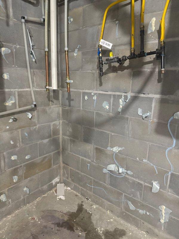 Responded to service call with scheduled arrival between 12-4 PM. Successfully disconnected and relocated water heater and water softener to center of room as requested. Removed water heater, water softener, and iron filter from utility area. Work completed in unfinished basement space with existing plumbing infrastructure including PVC, copper piping, and gas line assembly remaining in place.