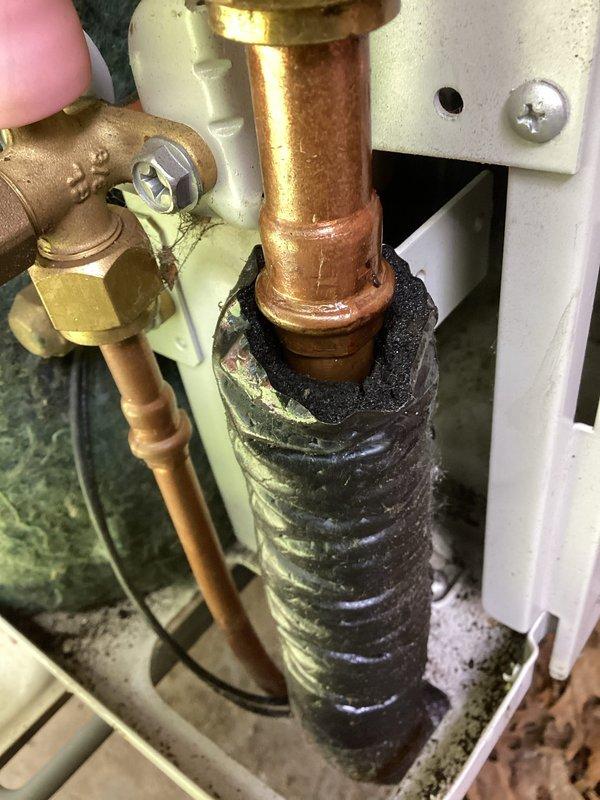 Responded to no cooling complaint on air conditioning system. Upon inspection, discovered refrigerant leak at flare fitting connection on copper refrigerant line. Identified failed press-on flare fitting as source of refrigerant loss causing inadequate cooling performance. Documented leak location with photos showing deteriorated fitting and moisture present at connection point. Recommended replacement of defective press-on flare fittings to restore proper system refrigerant charge and cooling capacity.