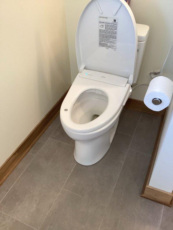 Completed installation of customer-supplied bidet attachment on existing two-piece toilet in residential bathroom. Unit was successfully mounted to toilet bowl, water supply line connected, and all control functions tested to ensure proper operation. Installation verified with no leaks detected at connection points.