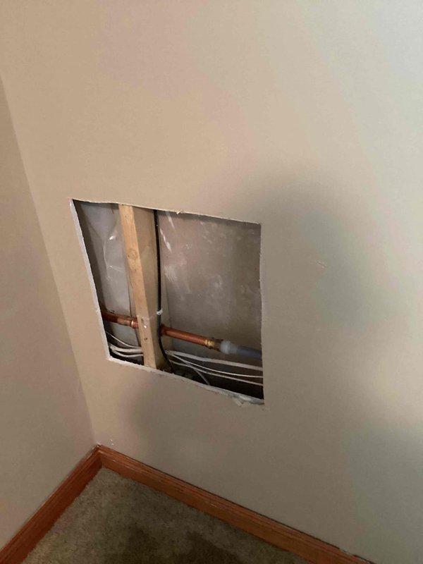 Responded to a water leak caused by a burst outdoor spigot that was leaking into the interior walls when in use. Accessed the affected area through an interior wall opening, disconnected and removed the failed outdoor faucet, and installed a new replacement unit. Restored water service to the home and verified proper operation with no leaks detected.