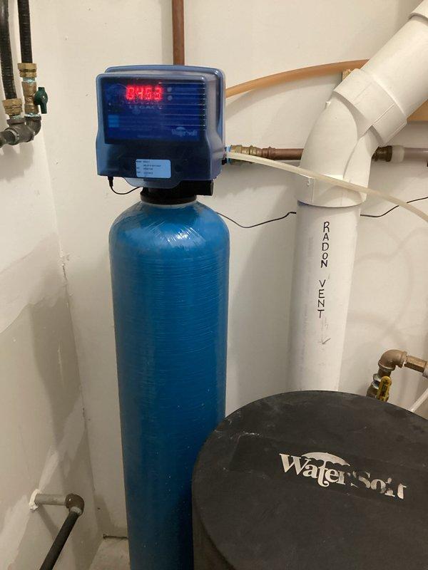 Responded to service call for malfunctioning WaterSoft Legacy View water softener system (Model DS24-3, 24K ISO III). Upon inspection, discovered brine tank was full of water, indicating regeneration cycle failure. Diagnosed control valve malfunction preventing proper brine draw and backwash cycles. Documented system specifications and photographed control head display readings and installation configuration for parts ordering purposes. Customer will obtain replacement parts directly through WaterSoft company, and technician will return for installation upon parts arrival.