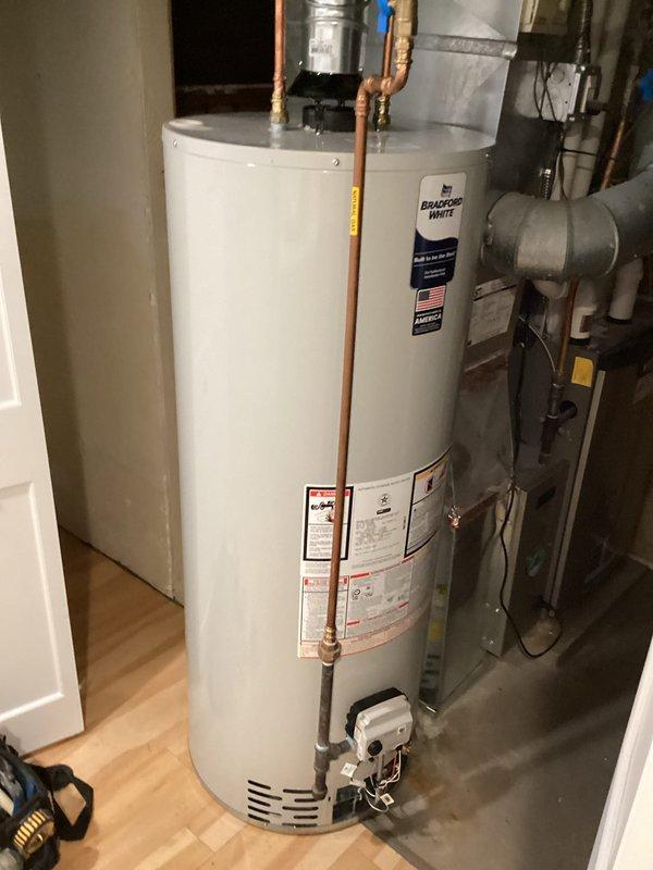 Removed existing 40-gallon water heater by draining the tank, disconnecting all water and gas connections, and hauling out the old unit. Installed new 50-gallon Bradford White atmospheric vent natural gas water heater in the same location, making all necessary copper piping connections, gas line connections, and venting attachments. Filled the tank, tested all connections for leaks, verified proper gas combustion, and confirmed the unit achieved full operational status with no issues detected.