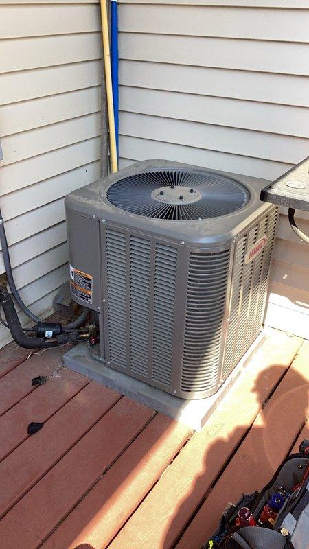 Responded to no cooling complaint on outdoor condensing unit. Upon arrival, performed diagnostic evaluation and determined system was low on refrigerant charge. Documented equipment condition with photos showing aged gray condenser unit with horizontal louvered panels positioned on wooden deck against building exterior. Provided repair estimate to address refrigerant loss and coordinated with project manager for approval to proceed with necessary repairs.