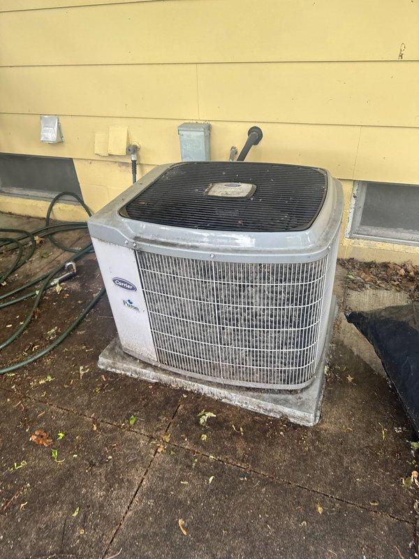 Responded to no cooling complaint on Carrier air conditioning system. Upon arrival, confirmed condenser fan motor was not operating. Diagnosed failed dual run capacitor at outdoor unit. Documented equipment condition with photos showing weathered condenser unit with accumulated debris and environmental wear. Provided written estimate for capacitor replacement to restore system operation, as property owner was unavailable for approval at time of service.